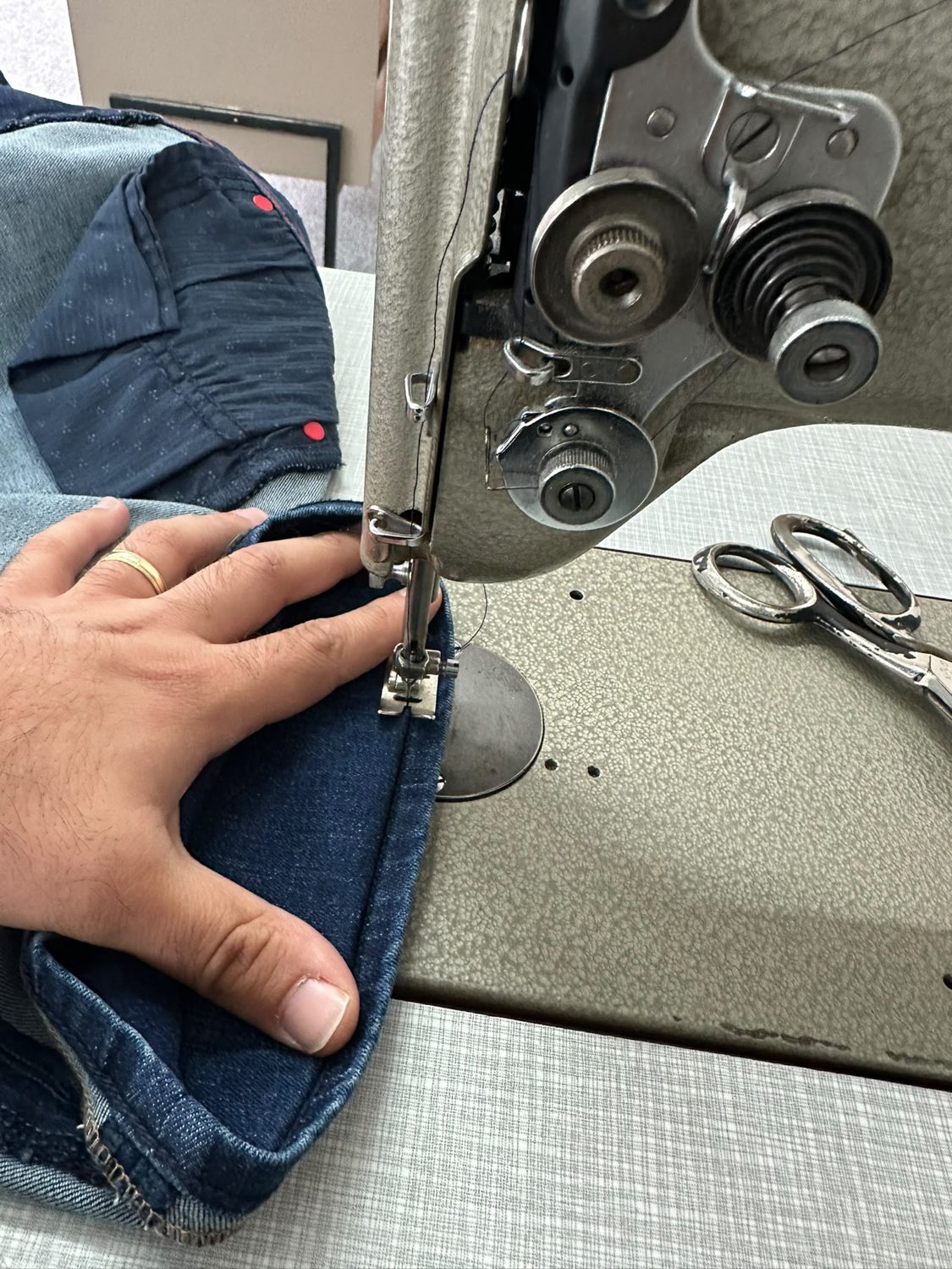 Jeans wird an der Nähmaschine in der Änderungsschneiderei Terzi gekürzt